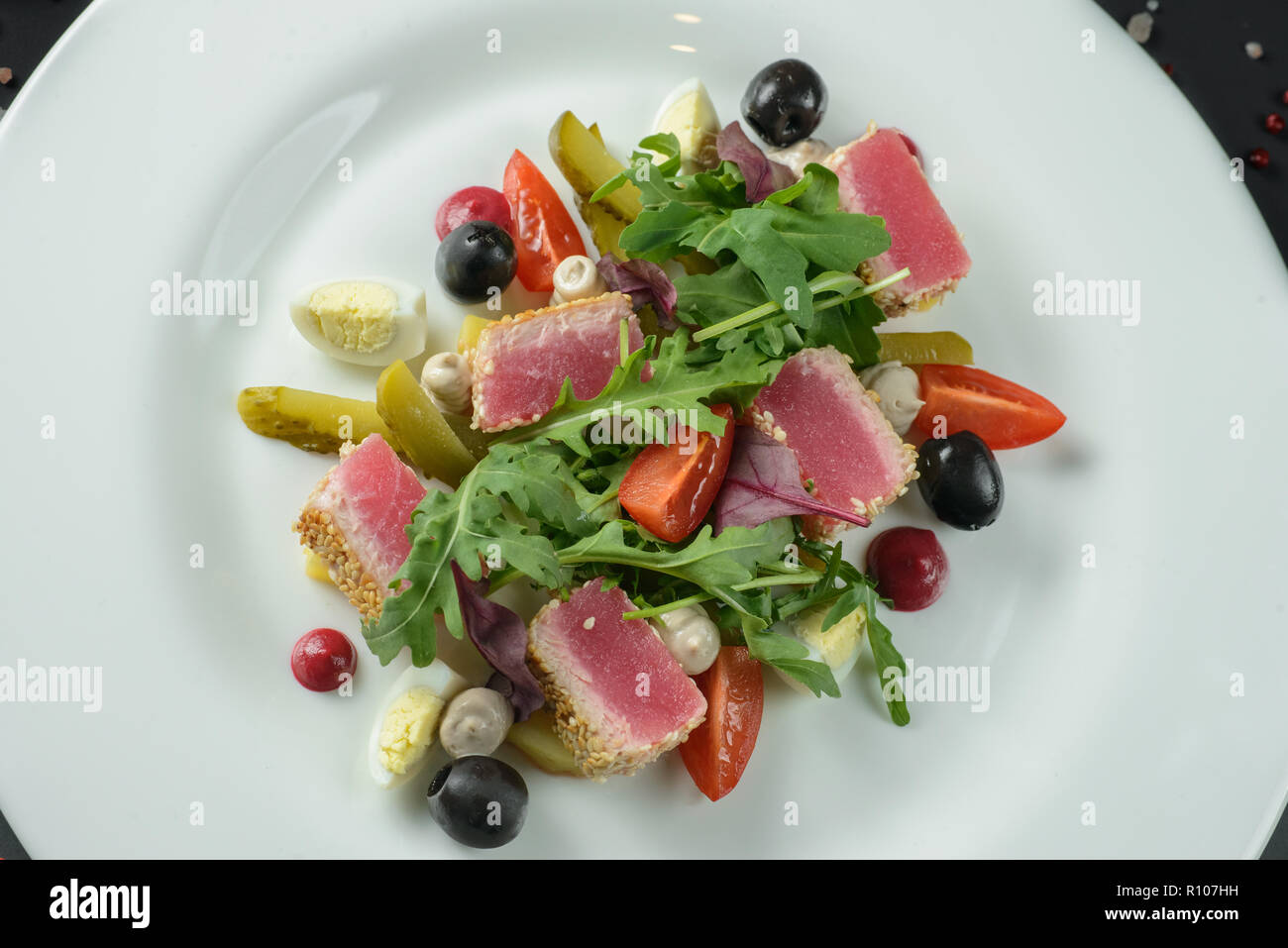 Salad with ham on white plate decorated on dark background Stock Photo
