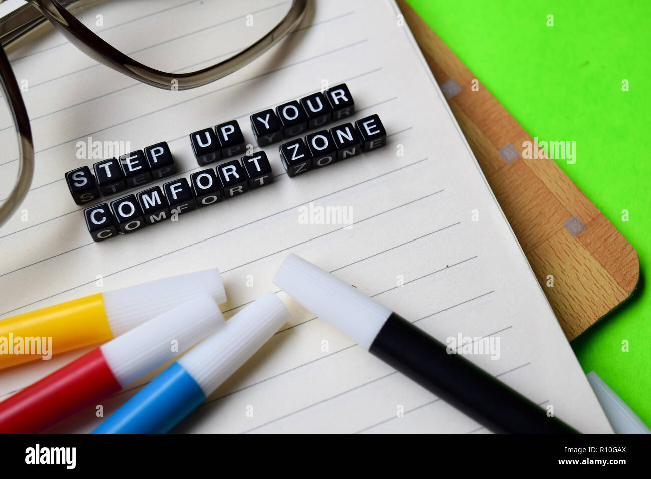 step up your comfort zone message written on wooden blocks. education and motivation concepts. Cross processed image on green Background Stock Photo