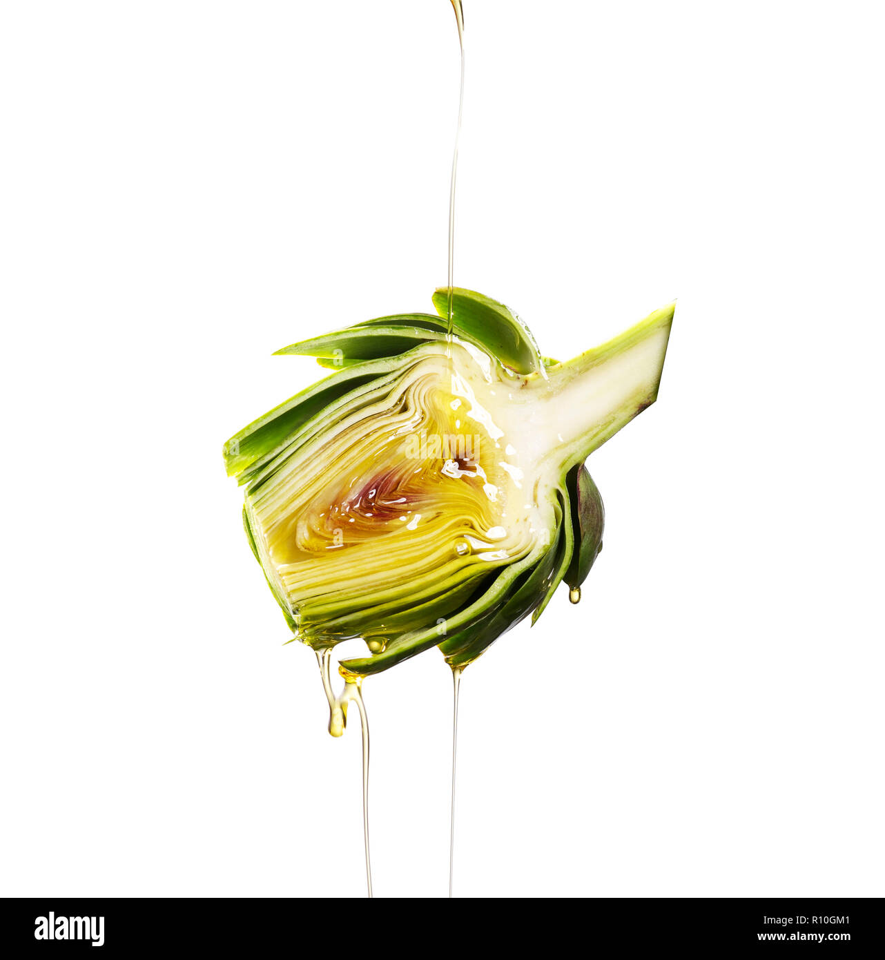 Sliced artichoke cross section with oil pouring on it, plain background Stock Photo