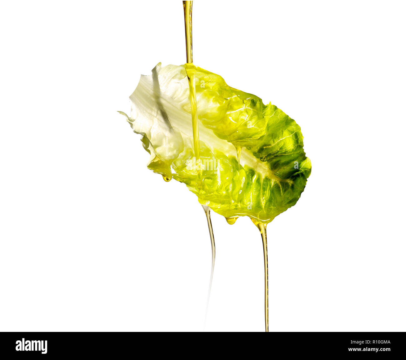 Oil pouring on floating lettuce leaf, white background Stock Photo