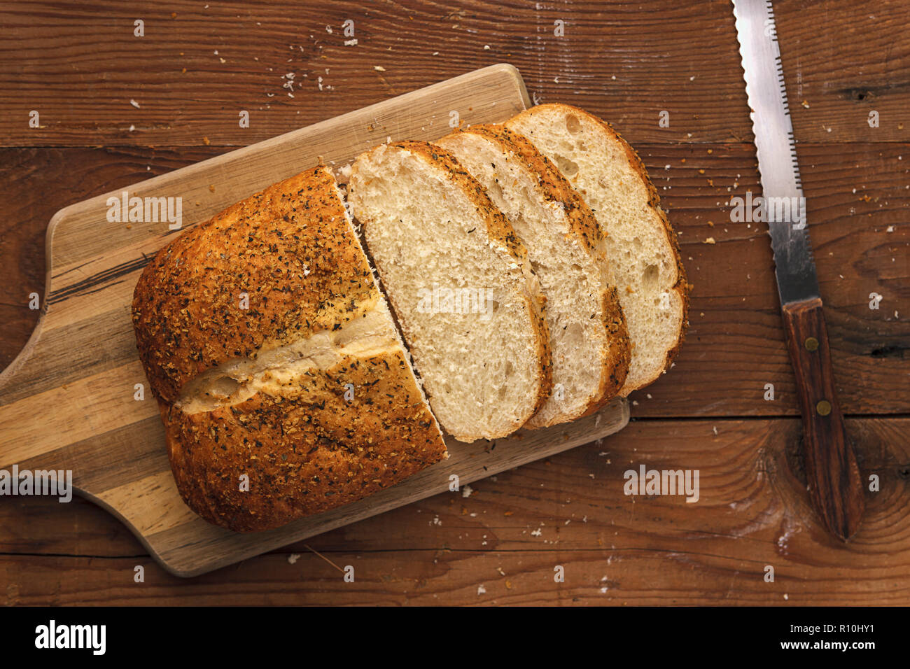 An overview of a loaf of bread with some slices on a wooden cutting ...