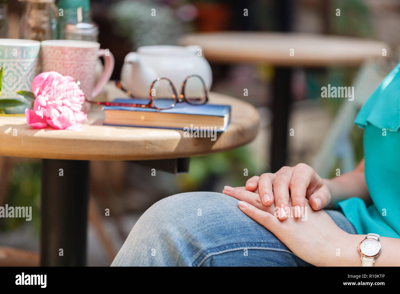 pretty woman sitting at the table in cafe and reading book Stock Photo ...