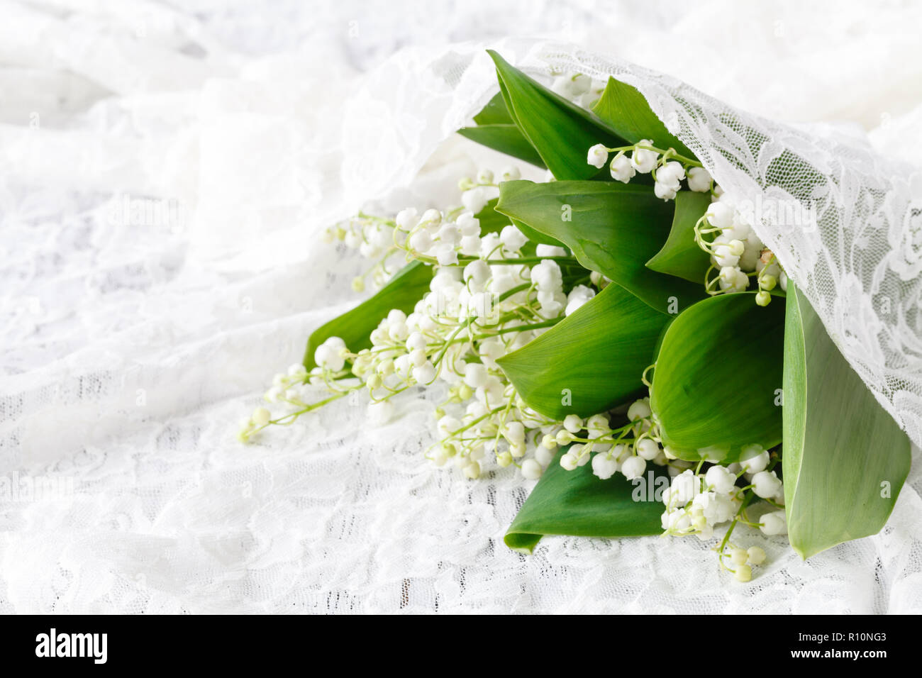 Lilies of the valley in a white porcelain vase Stock Photo