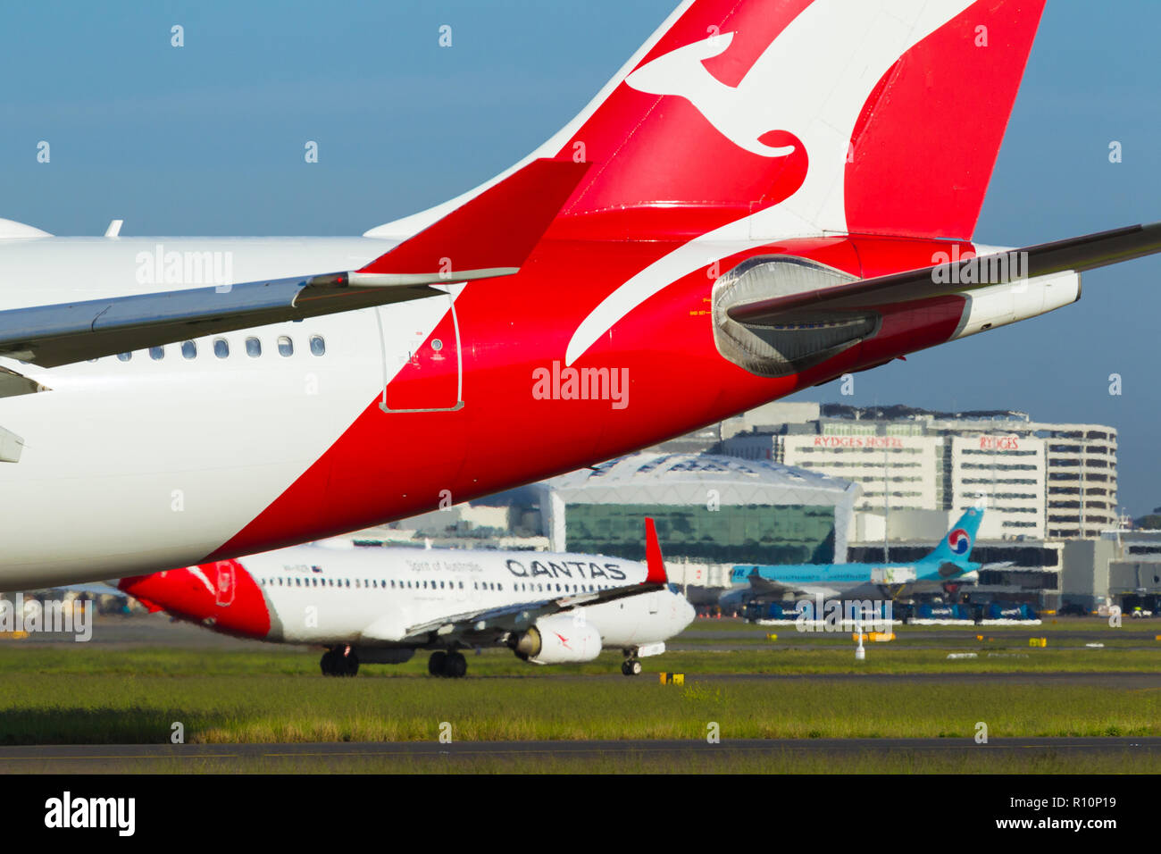 Detail from Sydney (Kingsford Smith) Airport in Sydney, Australia, looking  towards the International Terminal on the western side of the airport.  Pictured: a Qantas Airbus A330-202 (call sign VH-EBB) taxying, with a, image size:1300x956