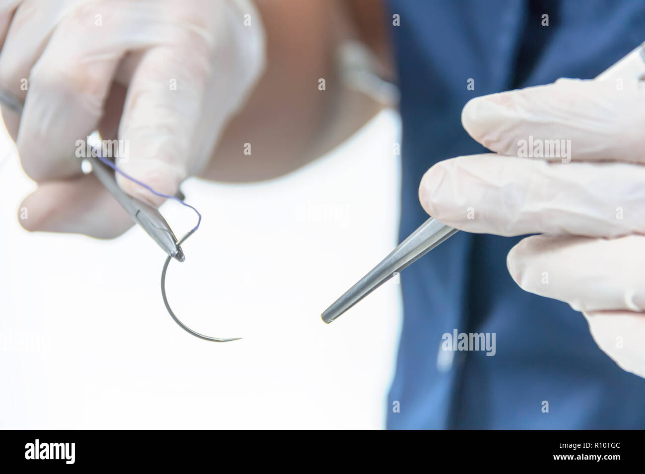 Doctor holding surgical forceps suture needle, suturing material Stock