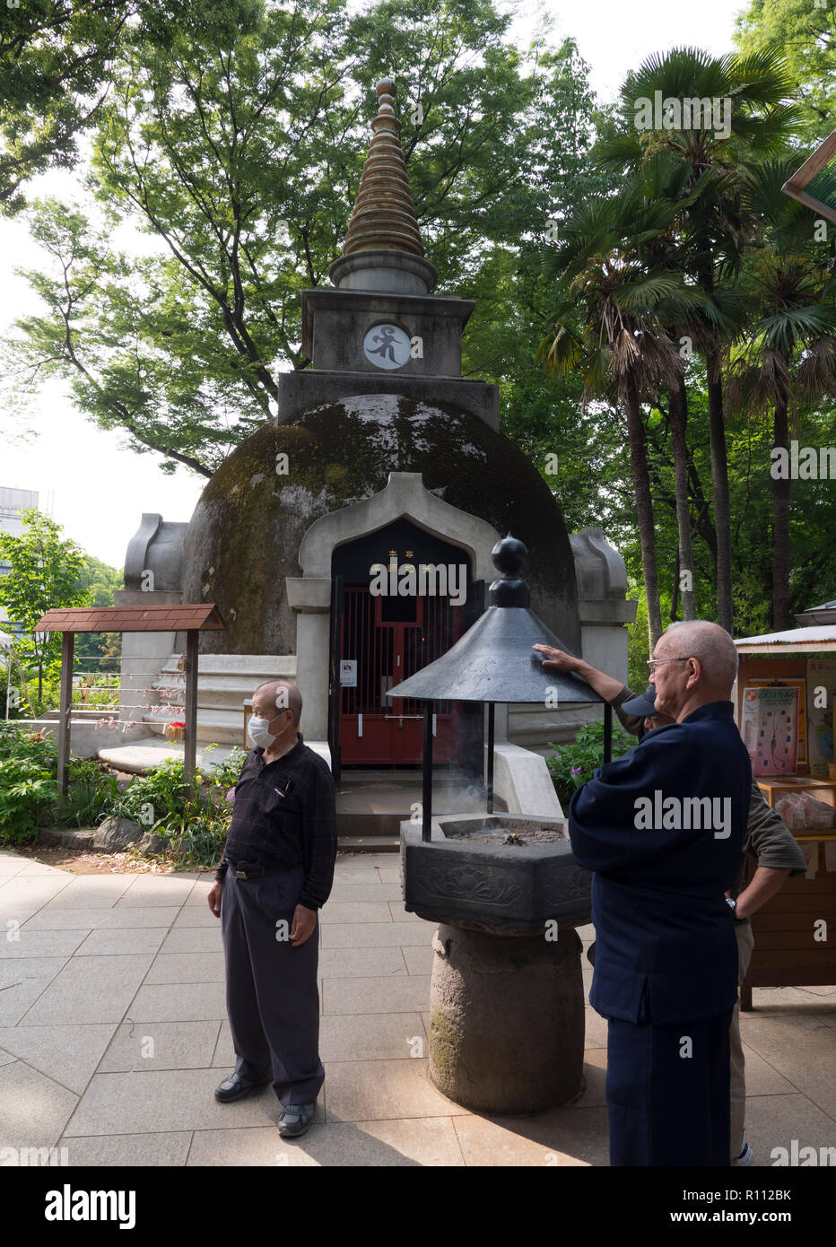 Men at the giant seated buddha statue Ueno Daibutsu in Uneo Park of