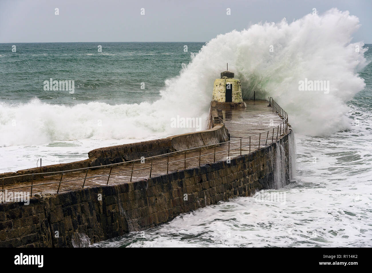 Portreath, Cornwall, UK. 04/11/2018. Gale force winds bring gigantic surf swells to Cornish harbour town of Portreath. Stock Photo