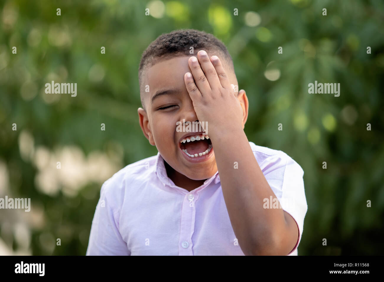 Happy child covering his eye in the park Stock Photo Alamy