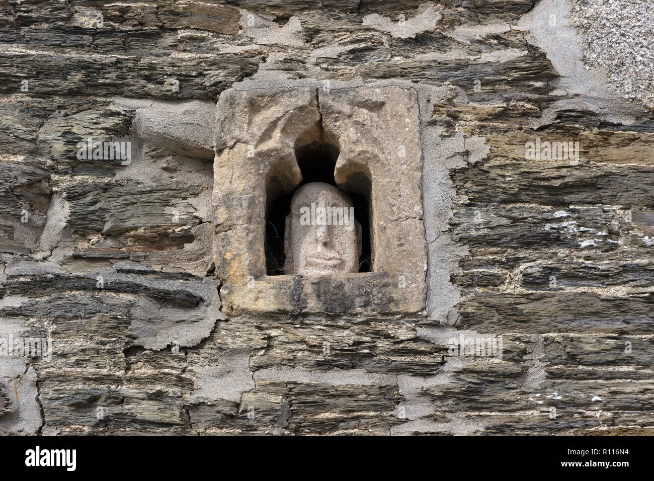 stone face in old wall, Padstow, Cornwall, England, Great Britain Stock Photo