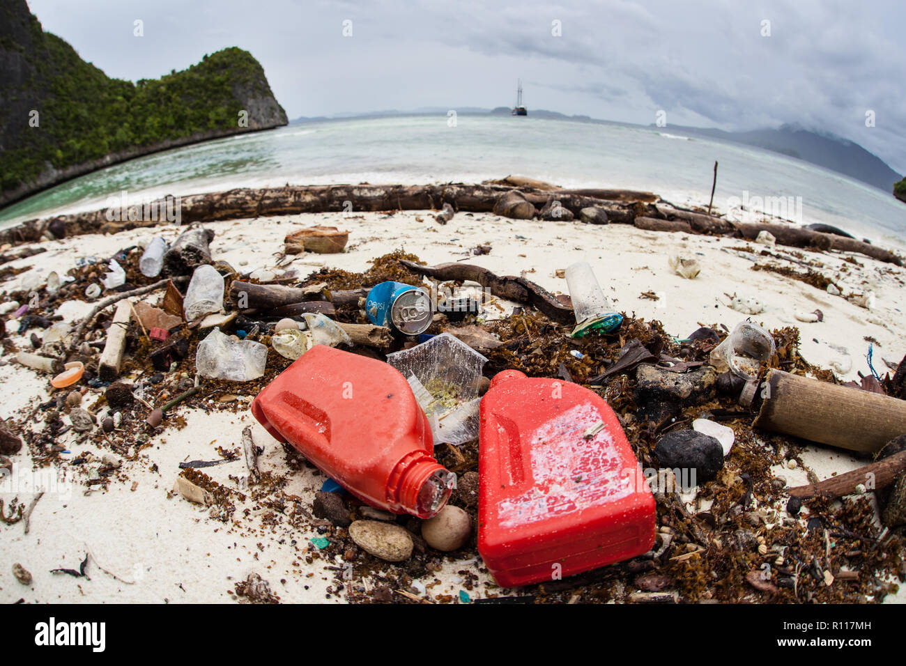 Discarded plastic bottles have washed up on a remote beach in Raja Ampat, Indonesia. Plastics break down into tiny pieces and enter the food chain. Stock Photo