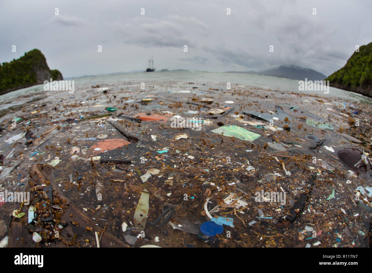Discarded plastic bits and pieces drift close to an island in Raja Ampat, Indonesia. Plastics break down into tiny pieces and enter the food chain. Stock Photo
