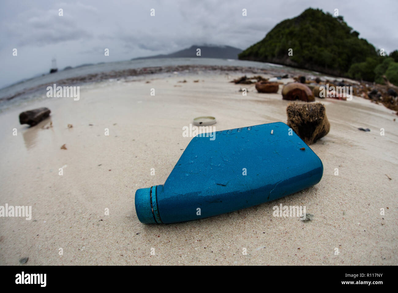 Discarded plastic bottles have washed up on a remote beach in Raja Ampat, Indonesia. Plastics break down into tiny pieces and enter the food chain. Stock Photo