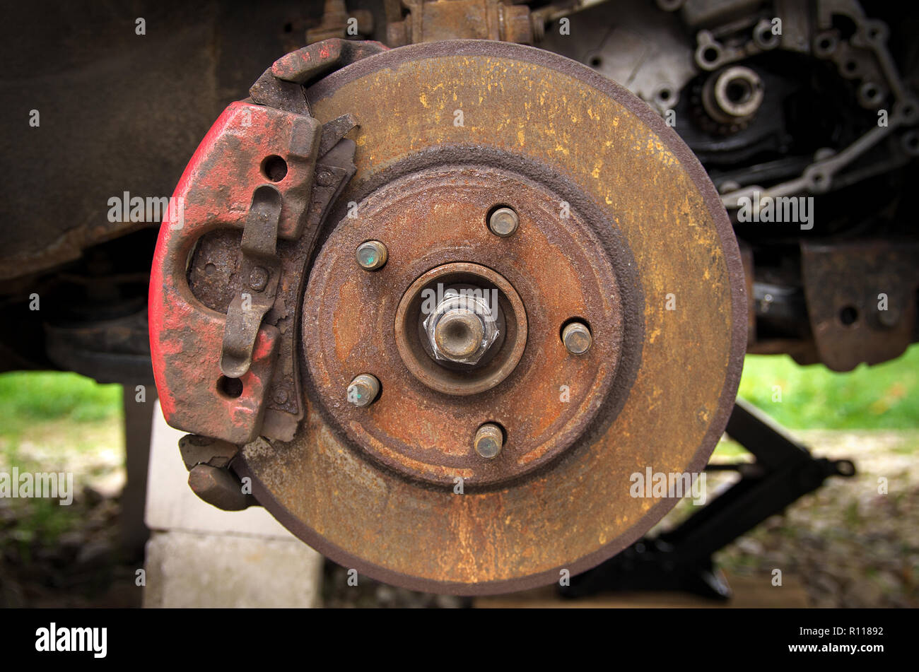 rusty brake disc, brake pad on a broken car in the yard Stock
