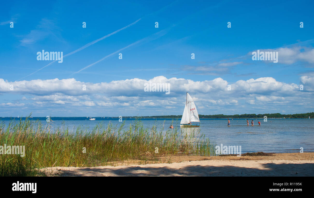 A sailboat and some bathers on the Lac de Biscarrosse Stock Photo
