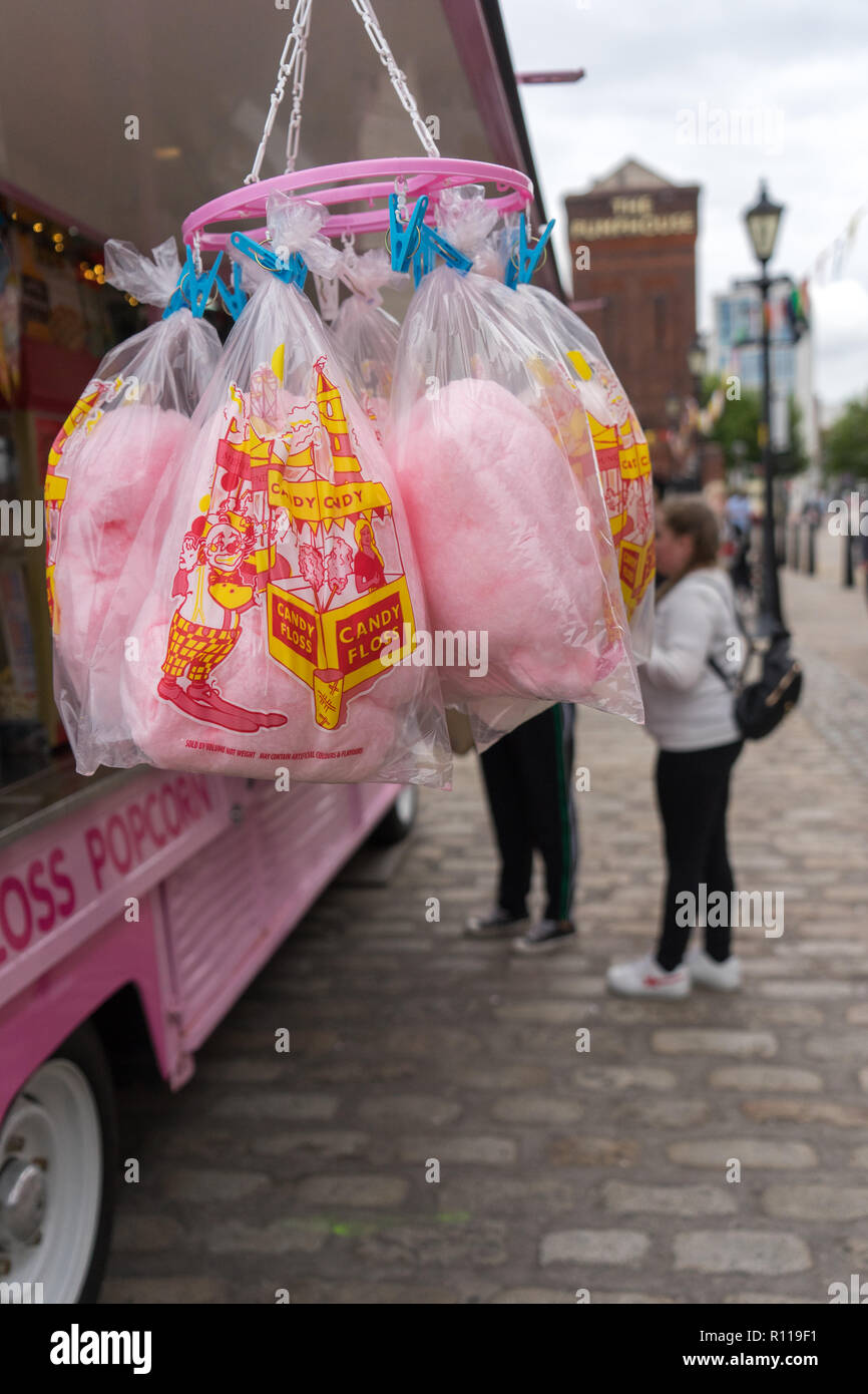 A street vendor selling candy floss and popcorn from a converted pink