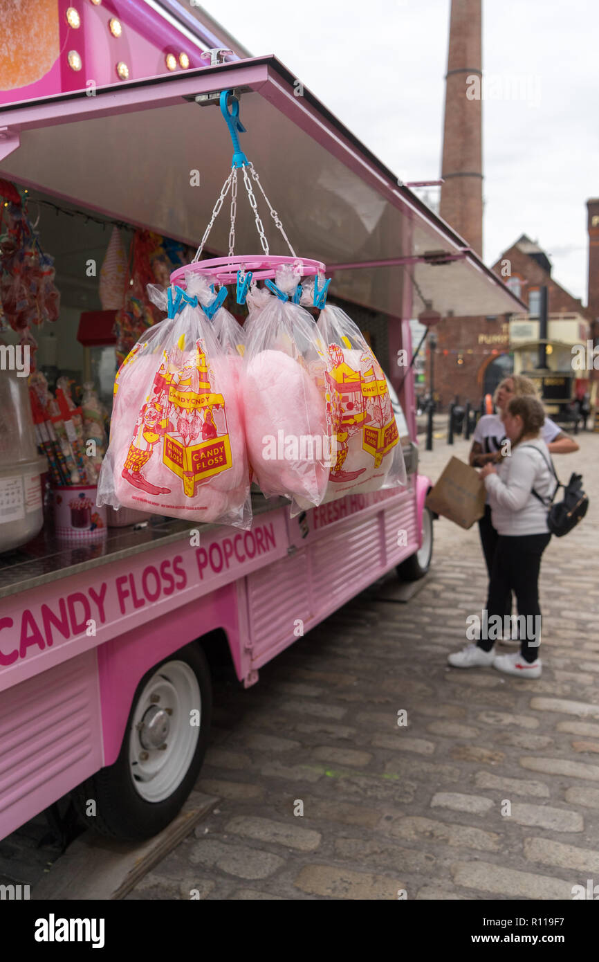 A street vendor selling candy floss and popcorn from a converted pink van at the Albert Dock in Liverpool Stock Photo