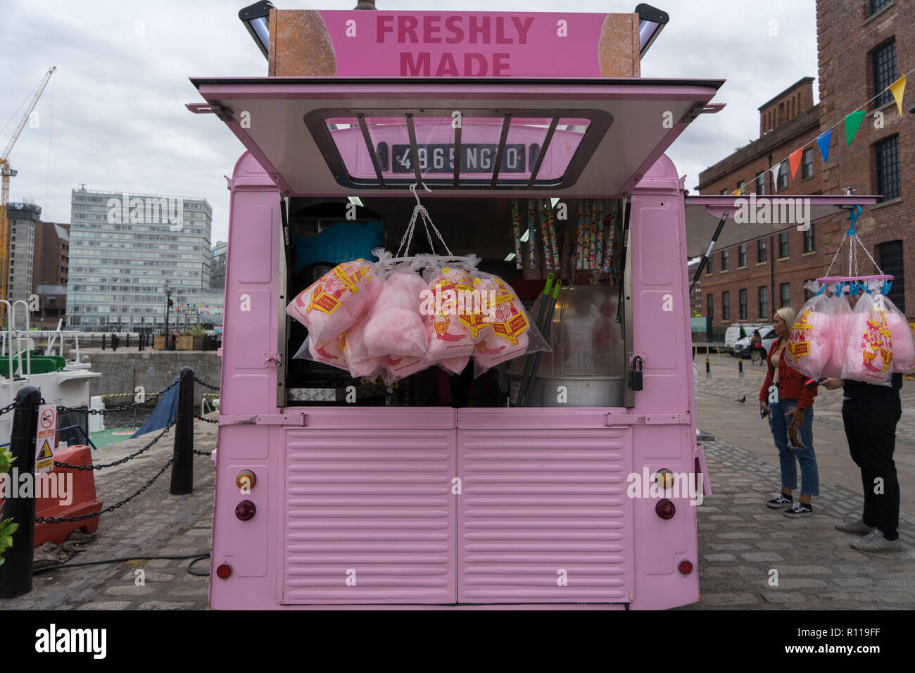 A street vendor selling candy floss and popcorn from a converted pink