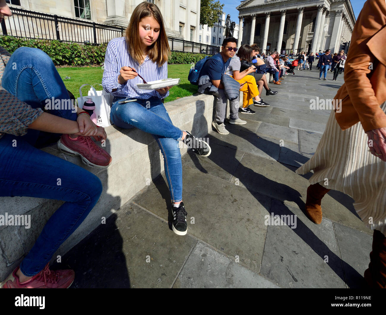 People relaxing at lunchtime in front of the National Gallery in Trafalgar Square, London, England, UK. Stock Photo