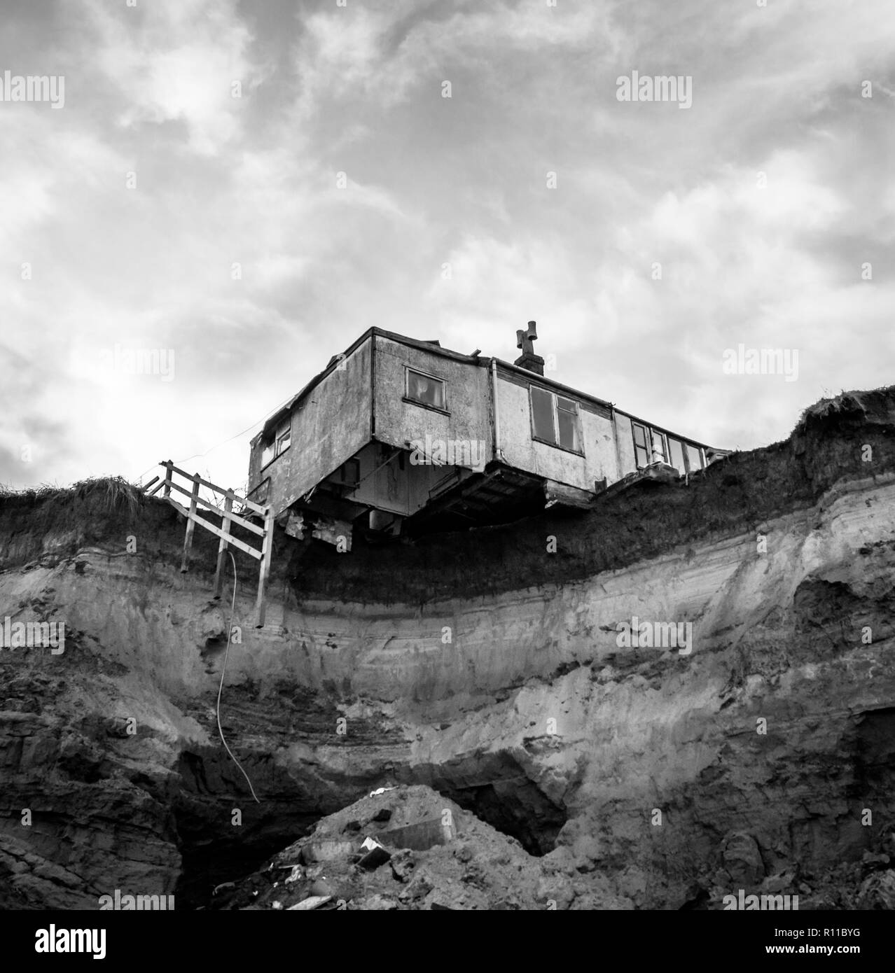 House on edge of cliff washed away by the sea, coastal erosion, global warming, rising sea levels, Happisburgh Norfolk, UK. View from underneath Stock Photo