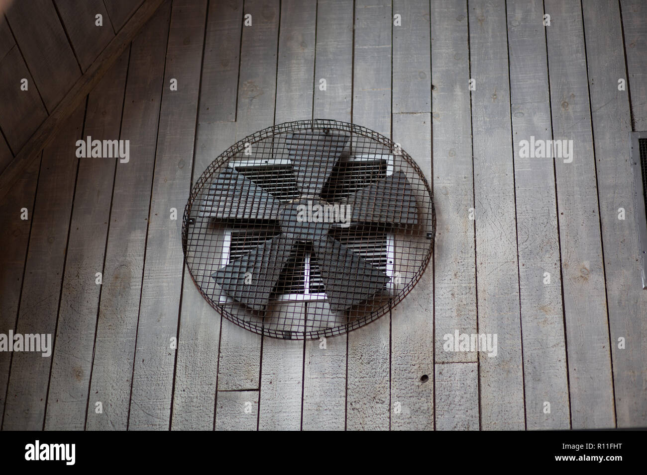 An extractor fan on a wooden wall Stock Photo