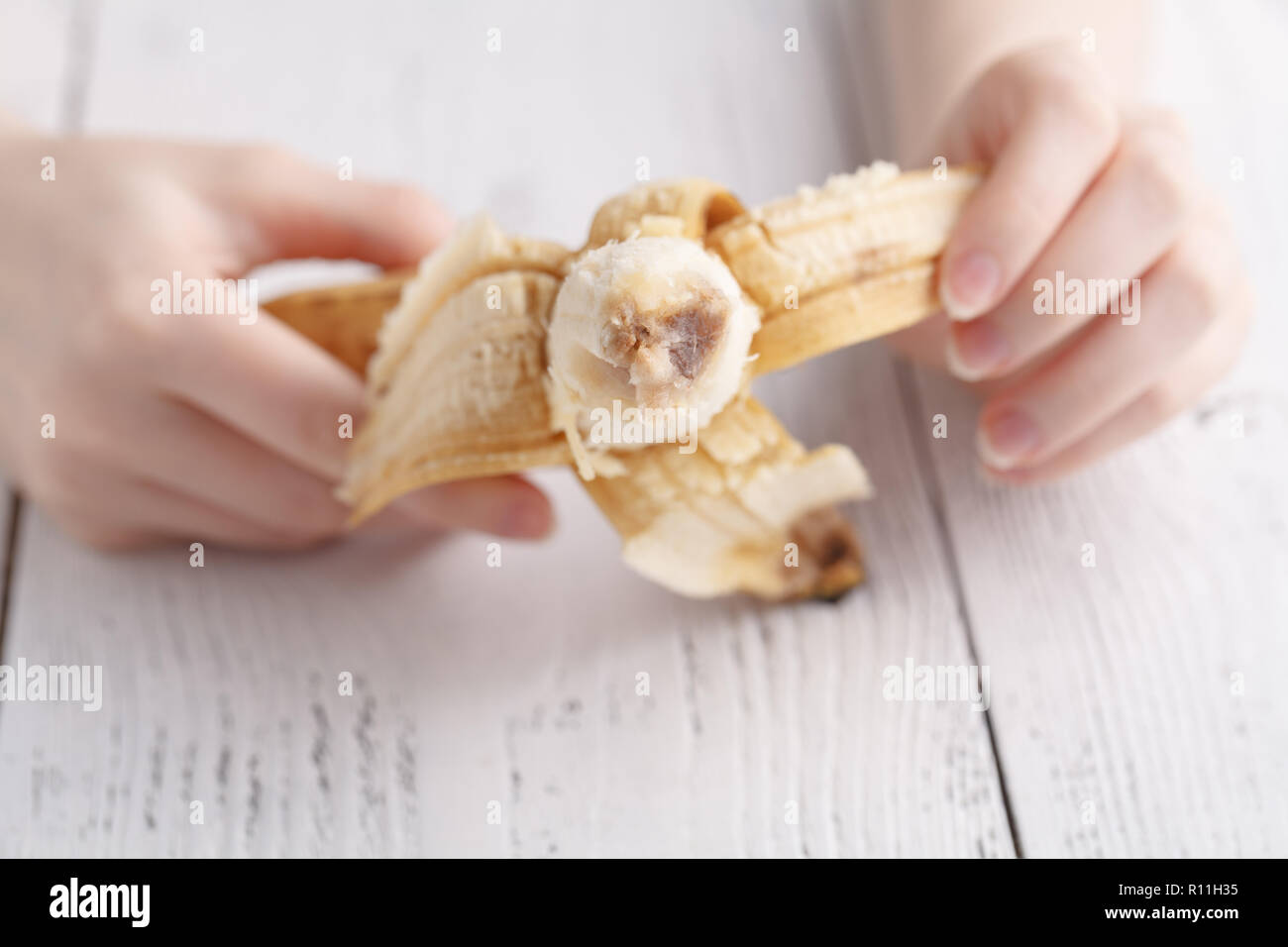 Opening banana in female hands Stock Photo Alamy
