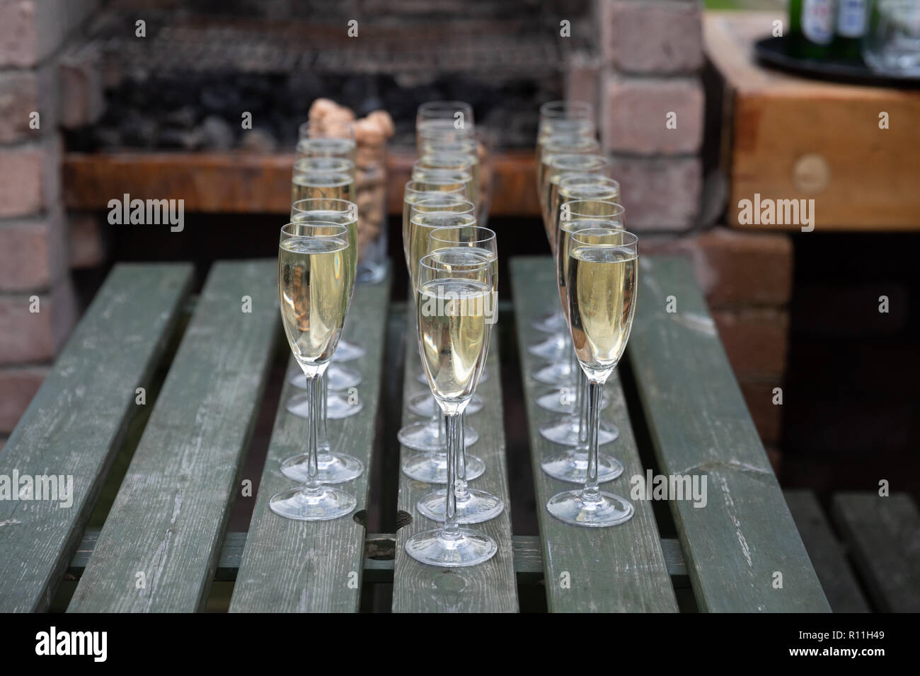 Three lines of champagne in glasses on a picnic table Stock Photo