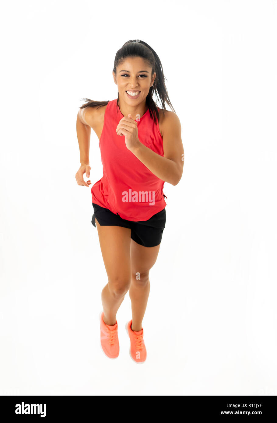 Young attractive happy latin woman in sport clothes with beautiful smile running and training on jogging workout isolated on white background in fitne Stock Photo