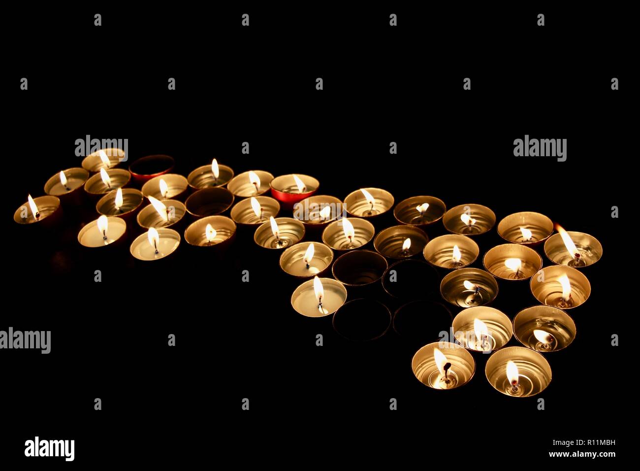 A bunch of candles burning sent as offerings and prayers Stock Photo