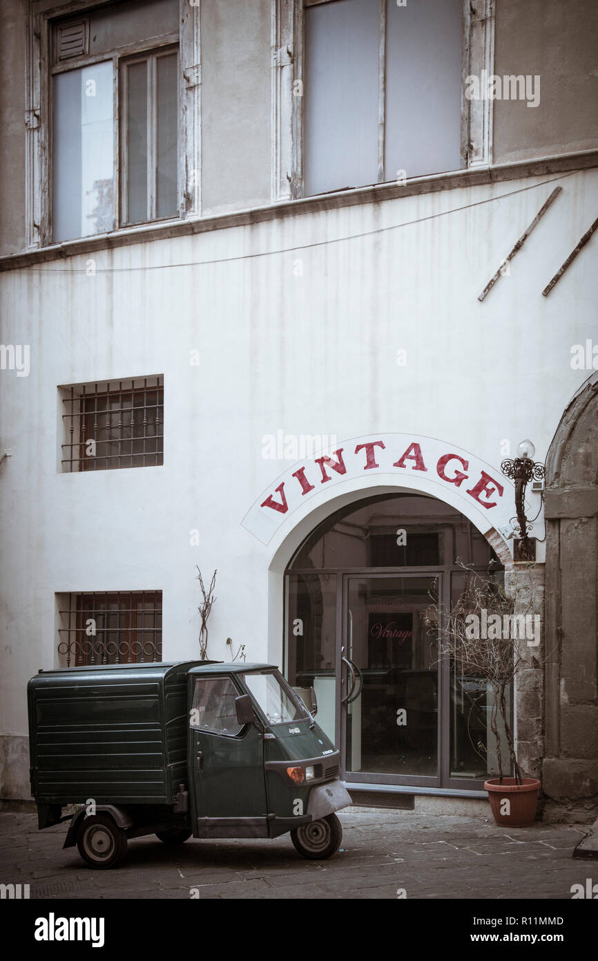 A miniscule Piaggio Ape 50 delivery truck packed in the back streets of Lucca, Italy. Stock Photo