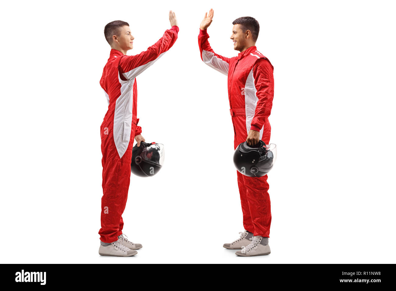 Full length profile shot of two racers high-fiving each other isolated on white background Stock Photo