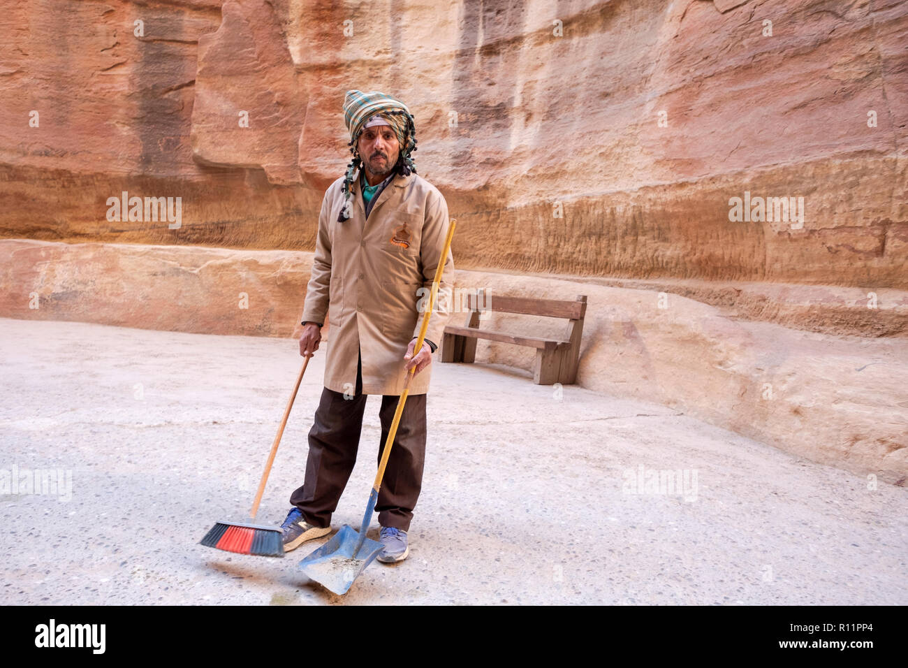 A Jordanian worker with a broom and shovel in Petra a historical and archeological city in South Jordan. Stock Photo