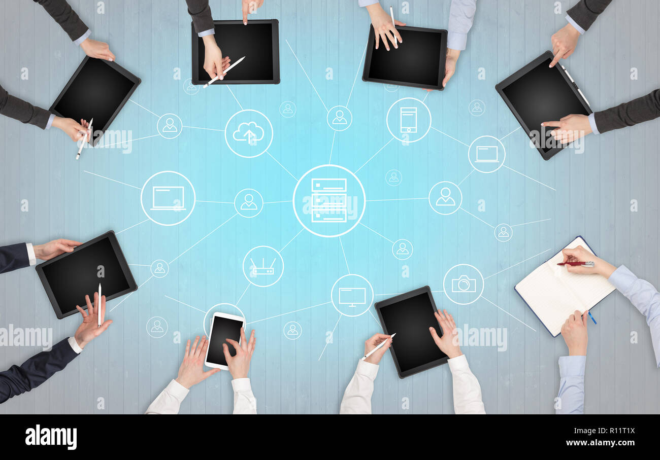 Group of people with devices in hands working in team on tablets ...