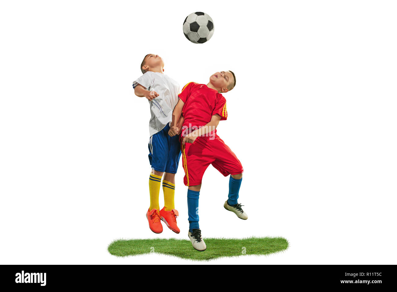 Young boys with soccer ball doing flying kick, isolated on white. football soccer players in motion on studio background. Fit jumping boys in action, jump, movement at game. Stock Photo
