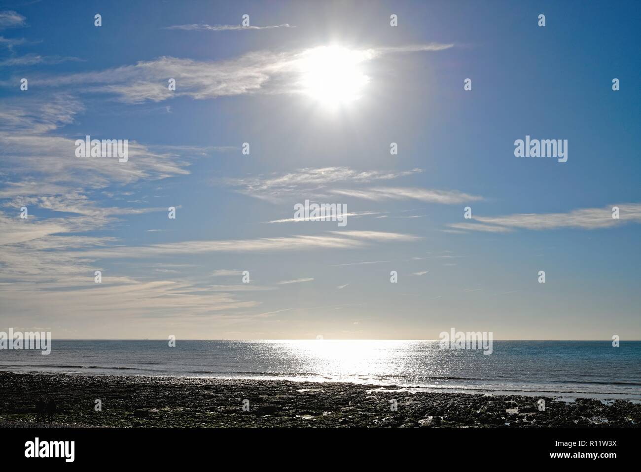 The sun reflecting off  the sea and horizon at Birling Gap East Sussex England UK Stock Photo