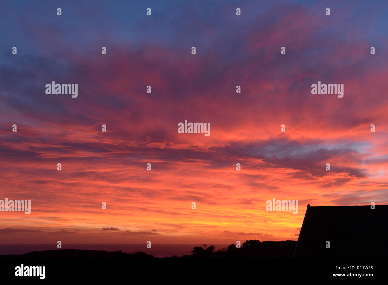 Sunset at Mumbles. A Setting Sun disappears below the horizon causing atmospheric refraction creating the beautiful spectrum of colours in the sky. Stock Photo