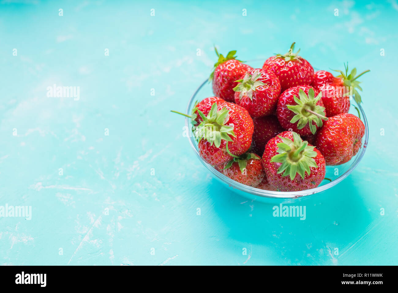 Fresh ripe strawberries in bowl isolated on soft blue background ...