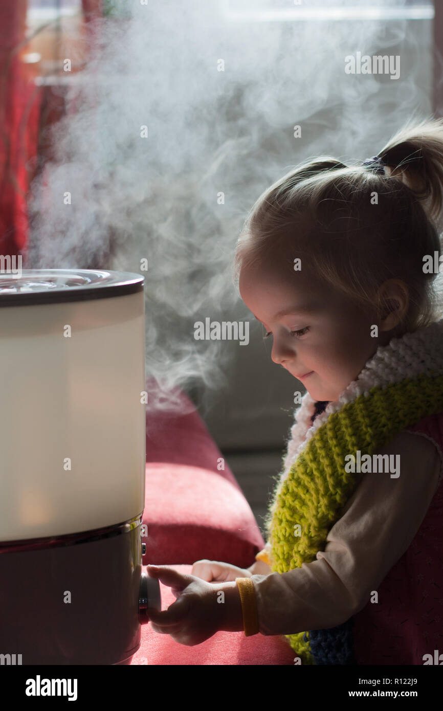 Little baby playing with humidifier Stock Photo - Alamy
