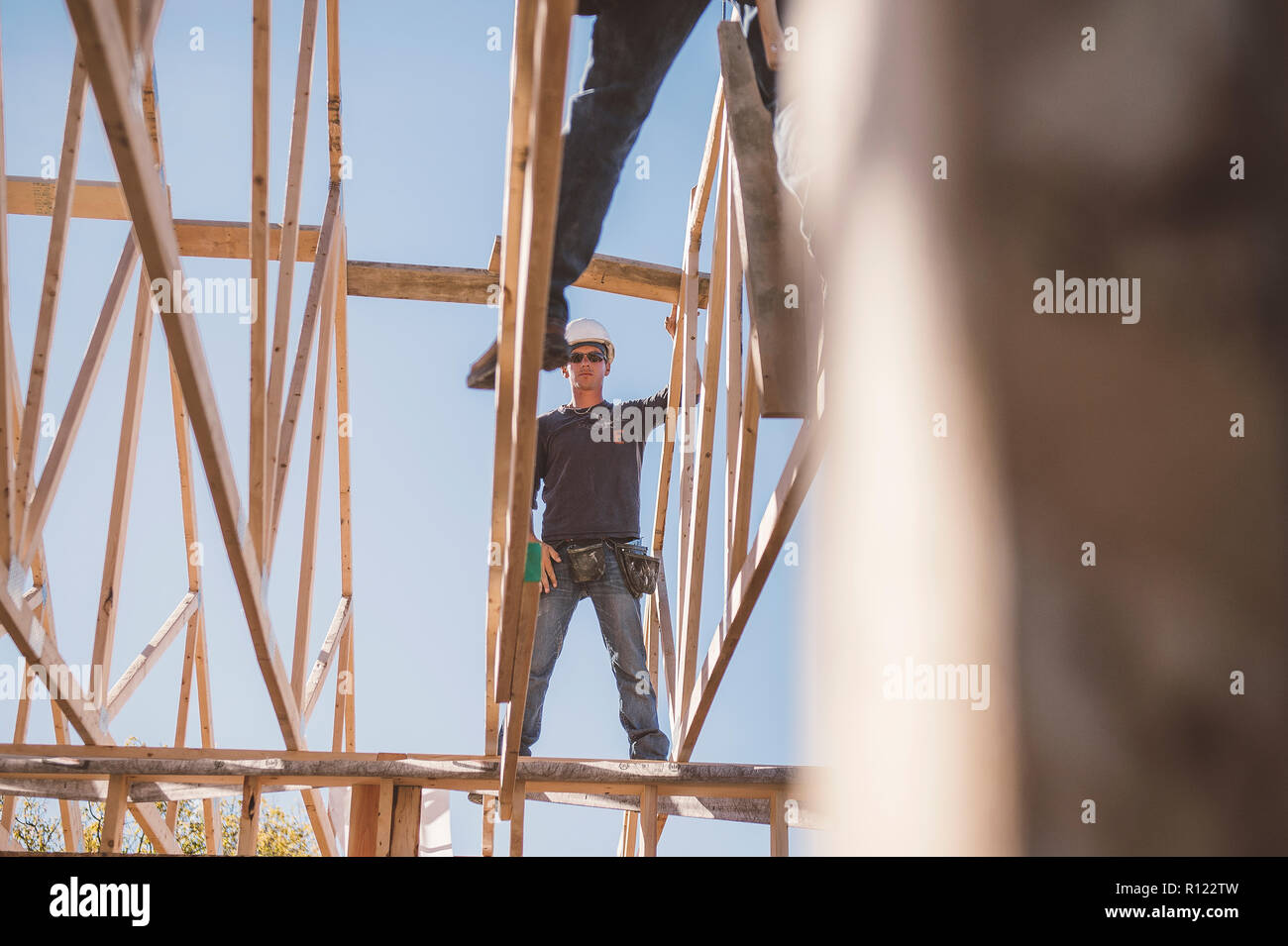 Builders working on rooftop frame of building Stock Photo