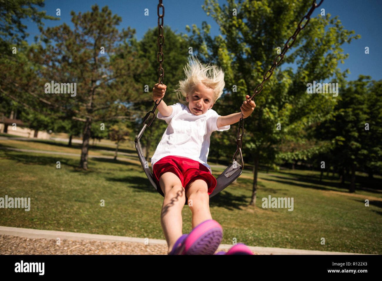 Boy on swing in park Stock Photo