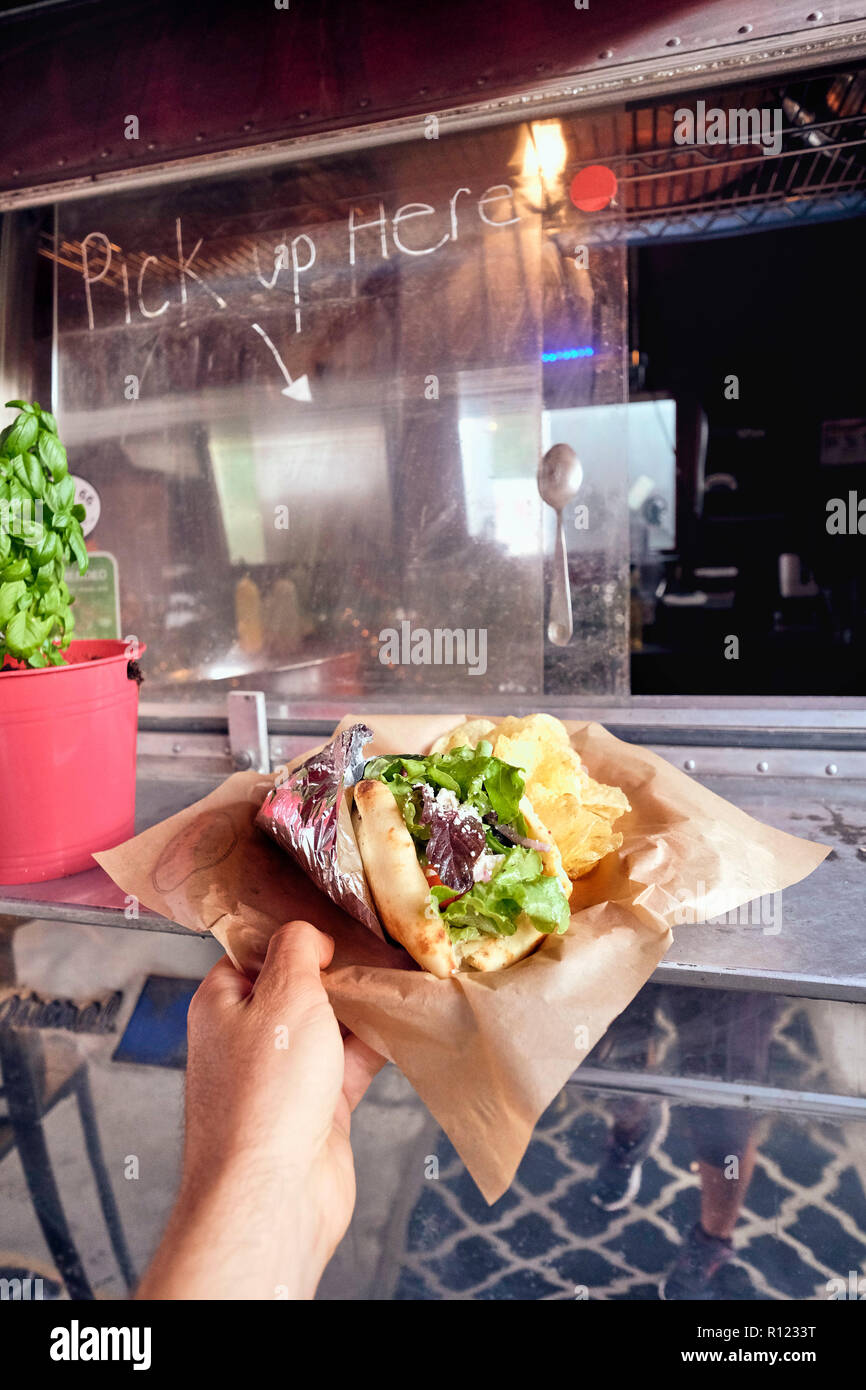 Salad wrap being collected from window of food truck Stock Photo