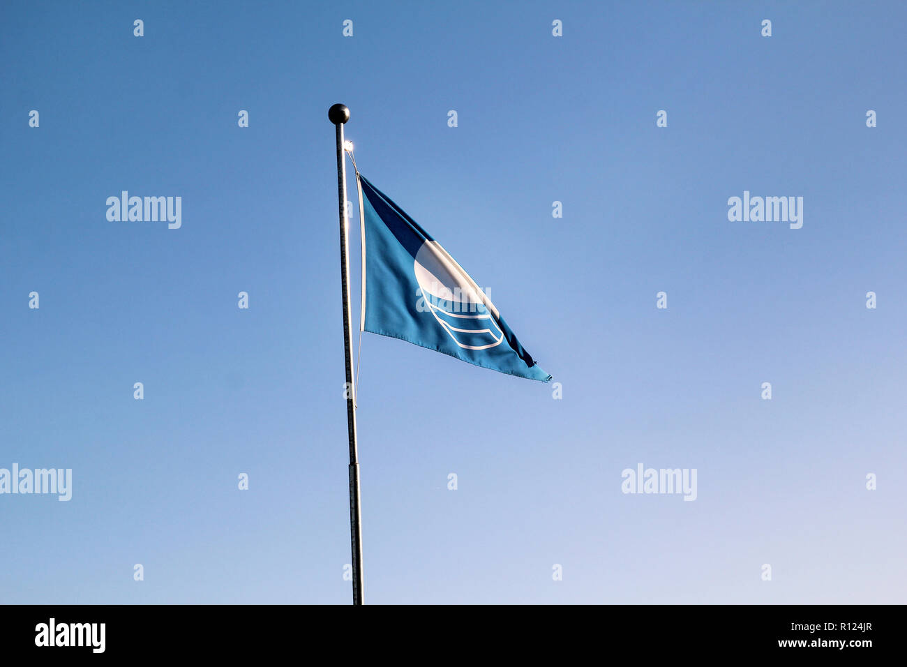 Detail of blue flag beach quality award flag flying, which means it has