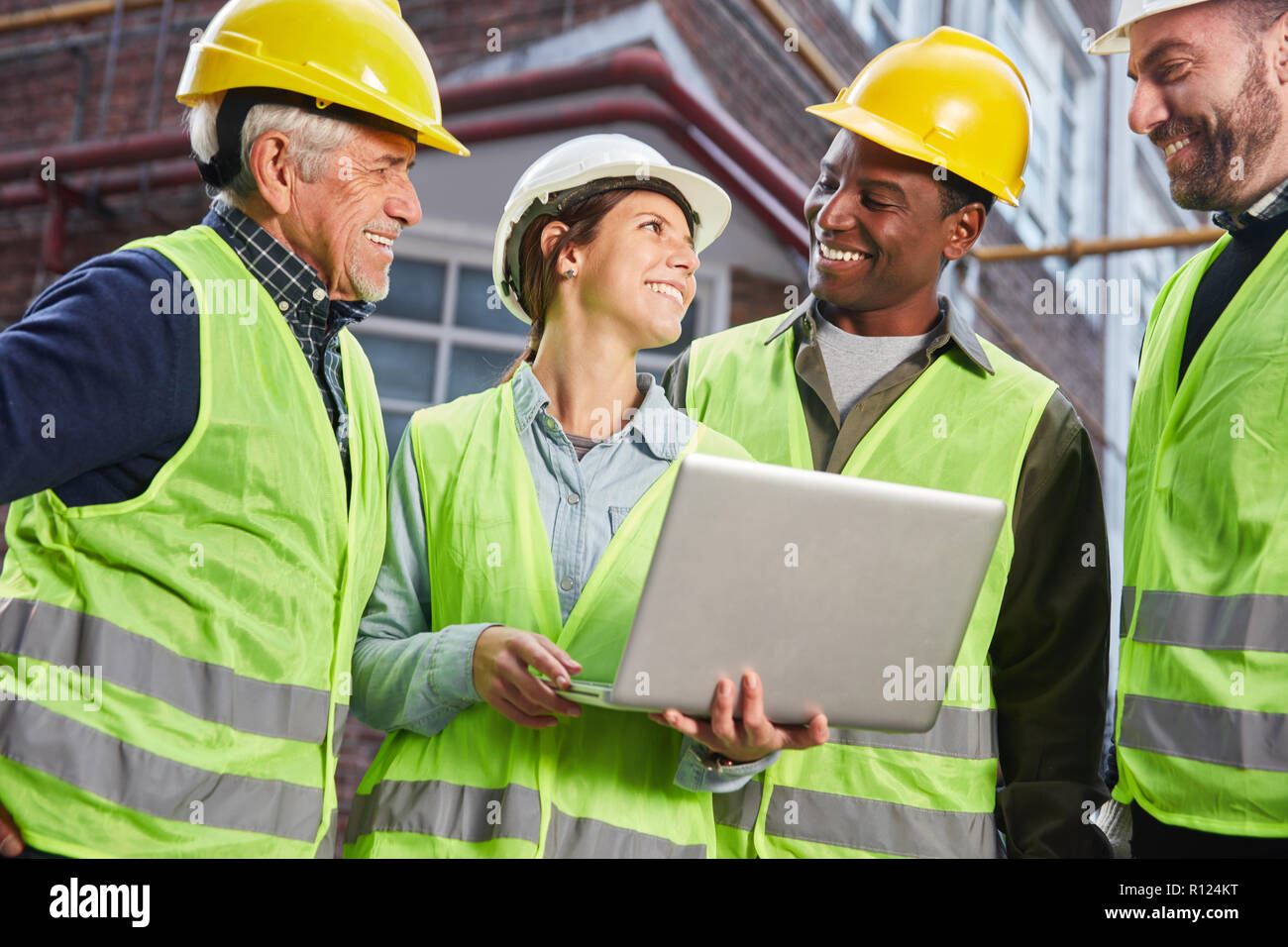 Happy logistics worker team with laptop PC in front of the logistics center Stock Photo