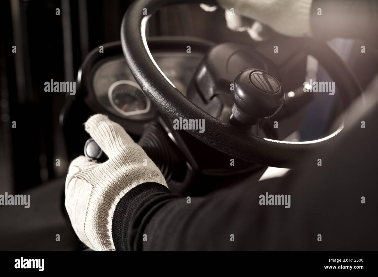 Hands on the steering wheel of a forklift truck in a logistics center Stock Photo
