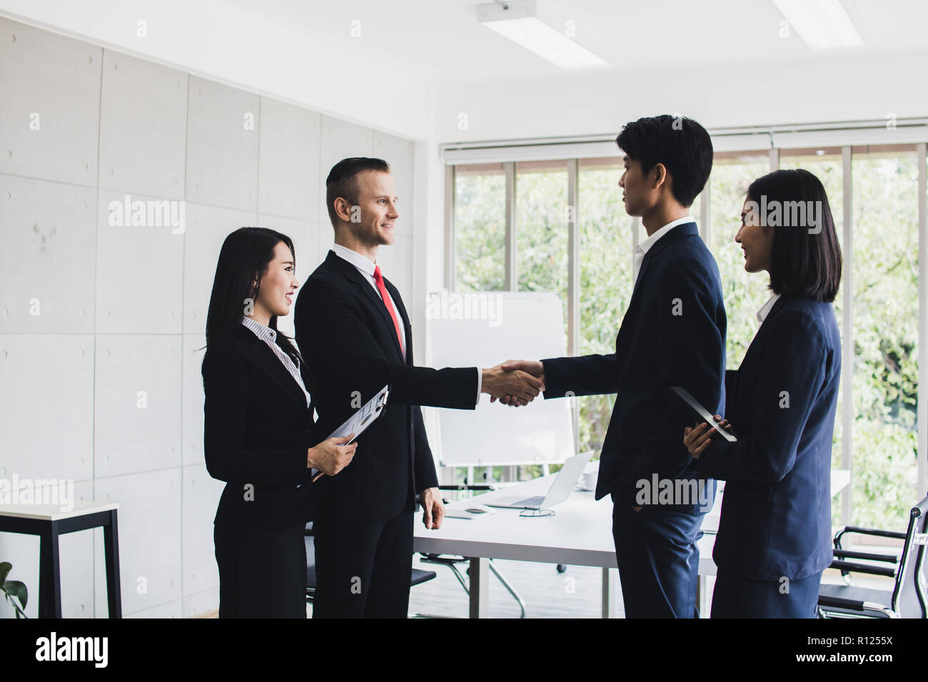 Europe business people shake hands and talking with Asian investor. Successful finished panther-ship and negotiation in meeting room Stock Photo