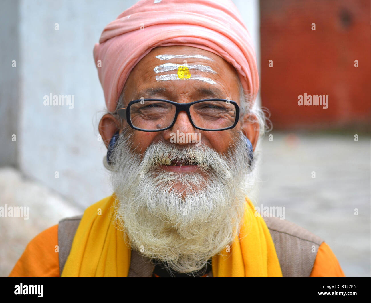 Shaivite Brahmin (Hindu priest who worships Shiva) with a freshly shampooed white beard and black earphones. Stock Photo