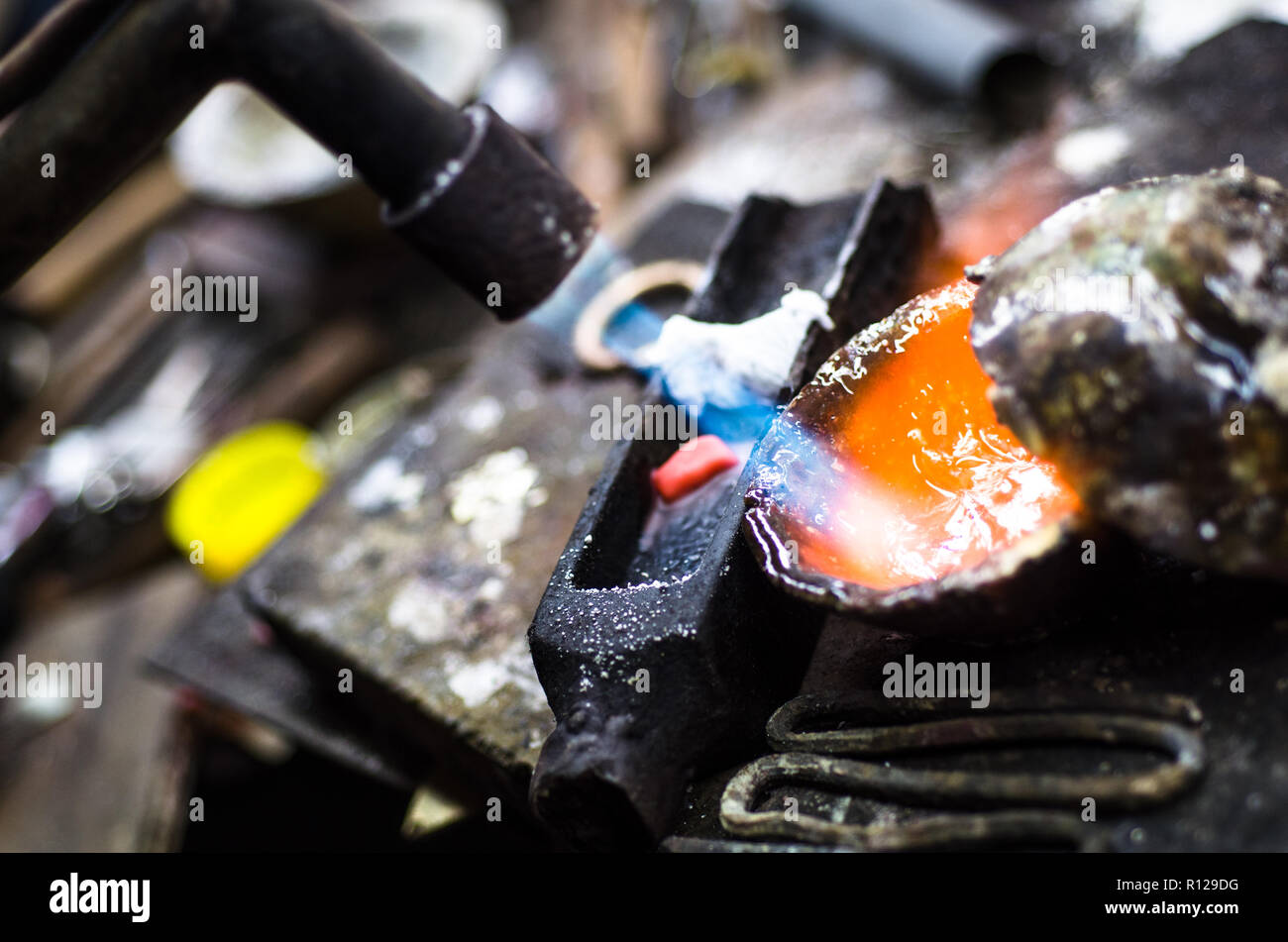 Craft jewellery making with professional tools. Macro shot. A handmade jewelry process, manufacture of jewellery. Melting silver Stock Photo