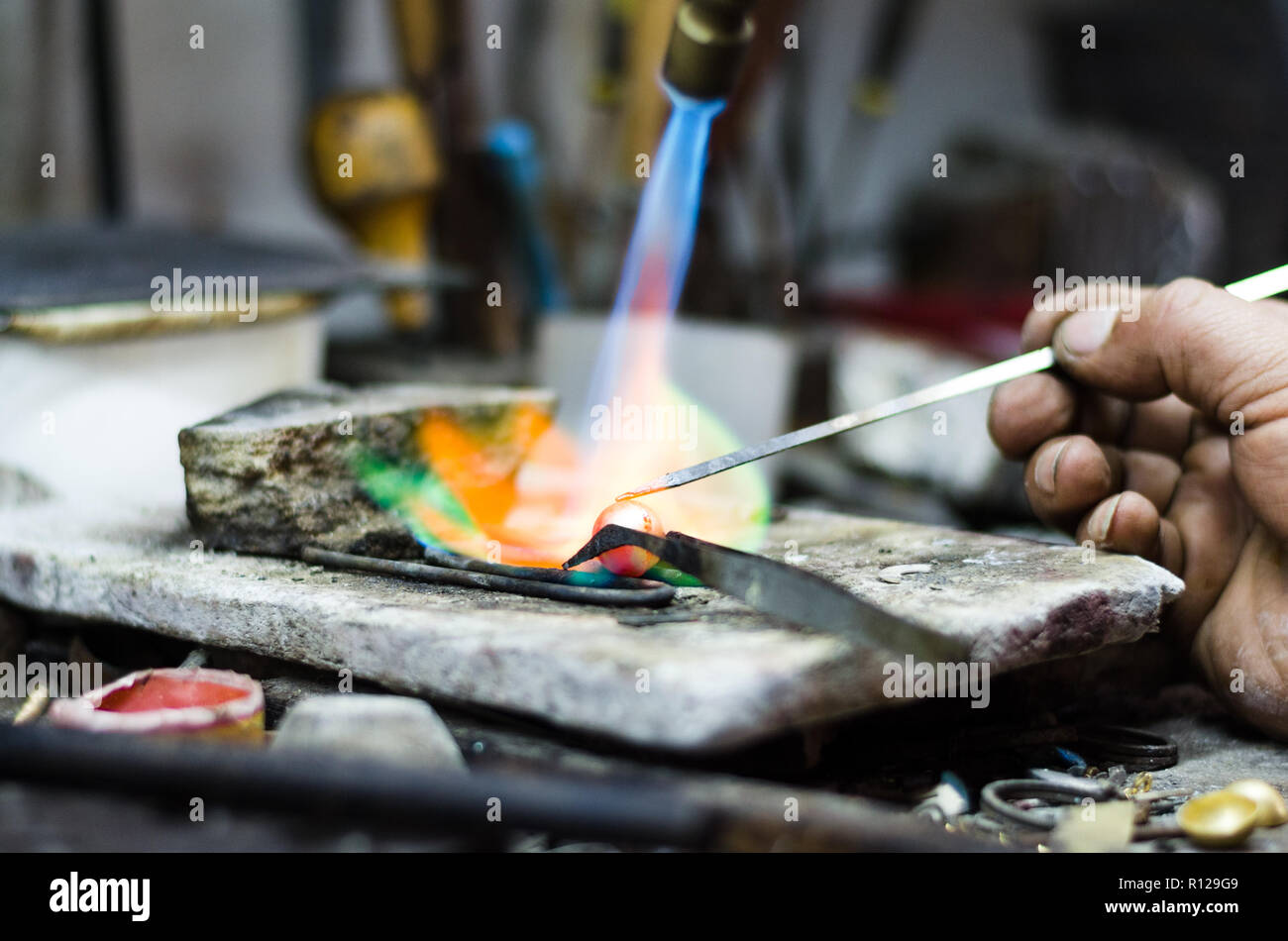 Master jeweler welding an ornament in a jewelry Image of