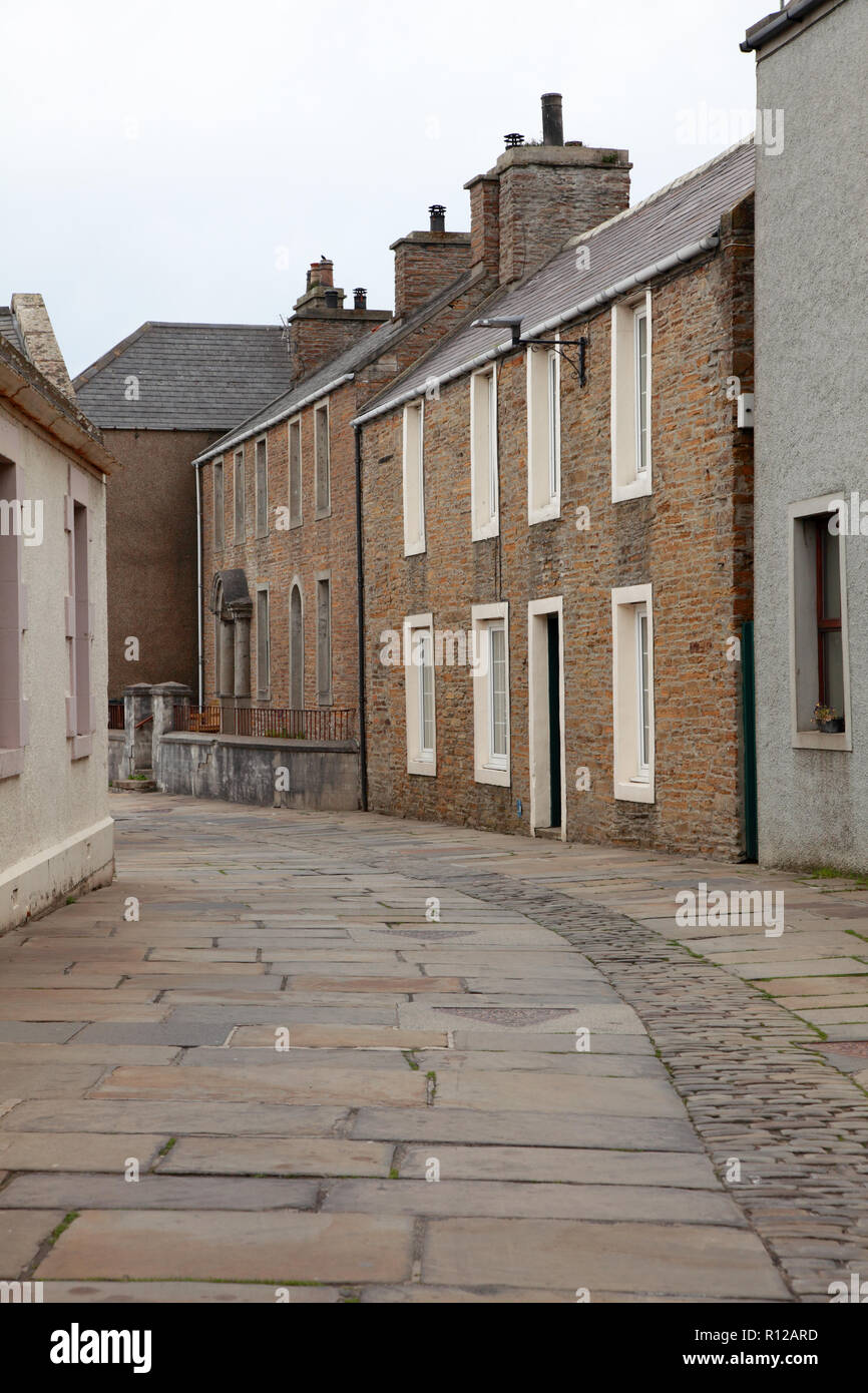Alfred Street in Stromness, Orkney with old paving stones from a quarry in Orphir and cobble stones in the centre of the street. Stock Photo