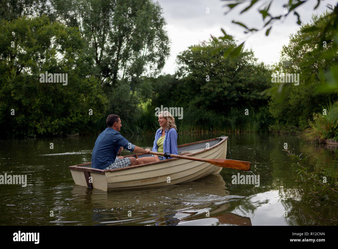 Mature couple in rowing boat on rural lake Stock Photo