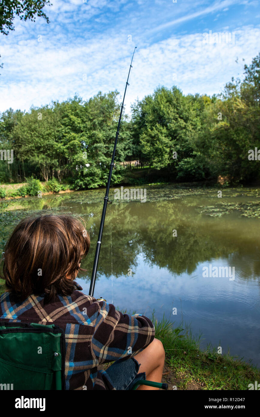 Boy fishing by lakeside, Bournemouth, UK Stock Photo